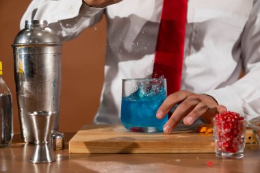 Barmen barda alkollü bir içecek hazırlıyor. Yanında da bir bardak likör.. 