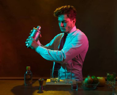 Barmen barda alkollü bir içecek hazırlıyor. Yanında da bir bardak likör.. 