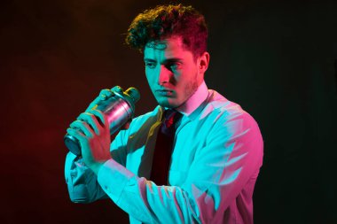 Barmen barda alkollü bir içecek hazırlıyor. Yanında da bir bardak likör.. 