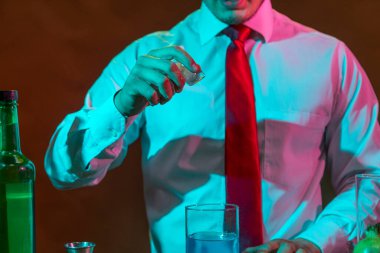 Barmen barda alkollü bir içecek hazırlıyor. Yanında da bir bardak likör.. 