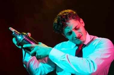 Barmen barda alkollü bir içecek hazırlıyor. Yanında da bir bardak likör.. 