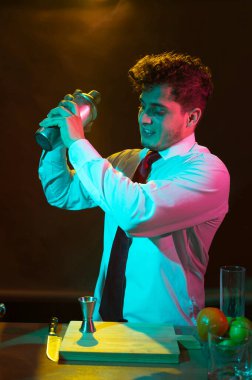 Barmen barda alkollü bir içecek hazırlıyor. Yanında da bir bardak likör.. 