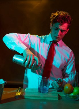 Barmen barda alkollü bir içecek hazırlıyor. Yanında da bir bardak likör.. 