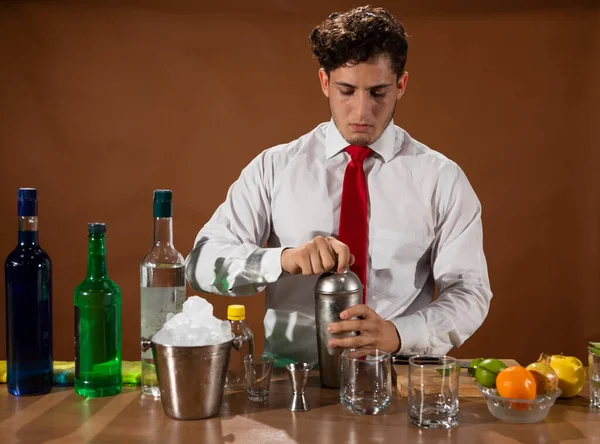 Barmen barda alkollü bir içecek hazırlıyor. Yanında da bir bardak likör.. 