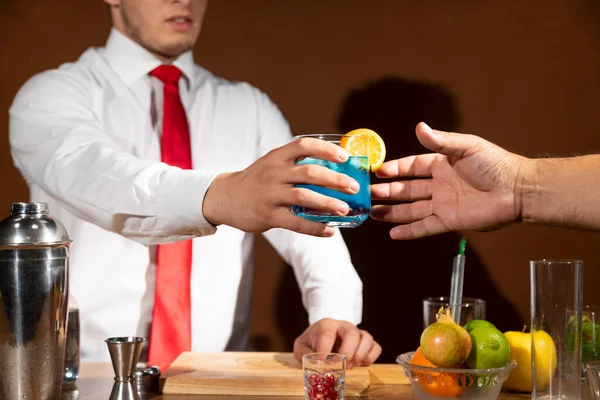 Barmen barda müşteriye alkollü içki servisi yapıyor. Dramatik ışıklar