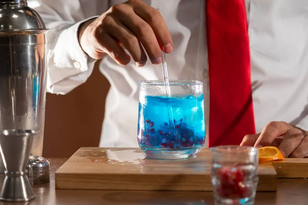 Barmen barda alkollü bir içecek hazırlıyor. Yanında da bir bardak likör.. 