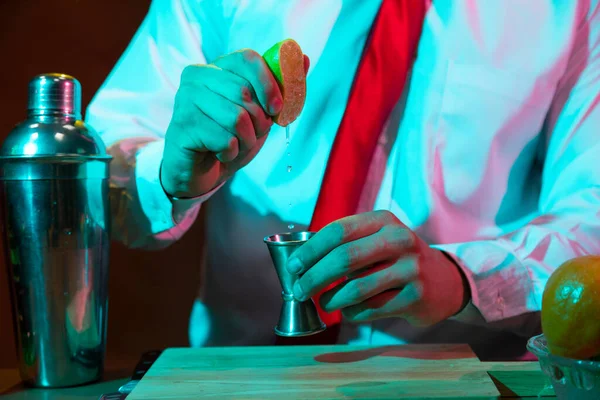 Barmen barda alkollü bir içecek hazırlıyor. Yanında da bir bardak likör.. 