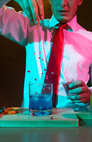 Barmen barda alkollü bir içecek hazırlıyor. Yanında da bir bardak likör.. 