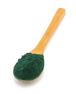 Beyaz zemin üzerinde yeşil toz bulunan tahta kaşık.