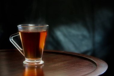 Ahşap masa cam bardakta sıcak siyah çay 