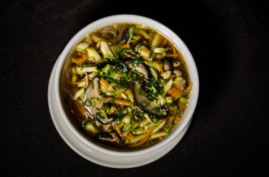 Siyah arka plan beyaz kase çorbaya Shiitake