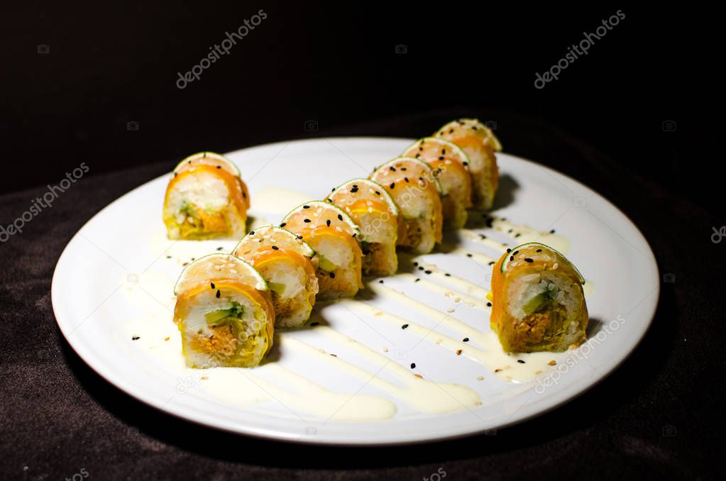 Sushi rolls in white plate and dark background