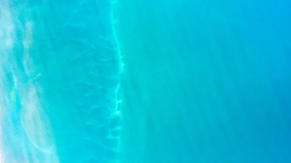 Sand, rock, and sea patterns on cristal clear waters.