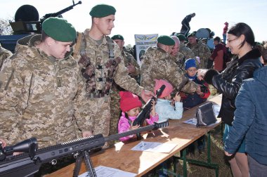 Mozhniakivka, Ukrayna - 14 Ekim 2018: Ukraynalı askerler çocuklar silahlarla Luhansk Bölgesi Mozhniakivka köyü Ukrayna'da Defender günü kutlamaları sırasında bilgi verir.