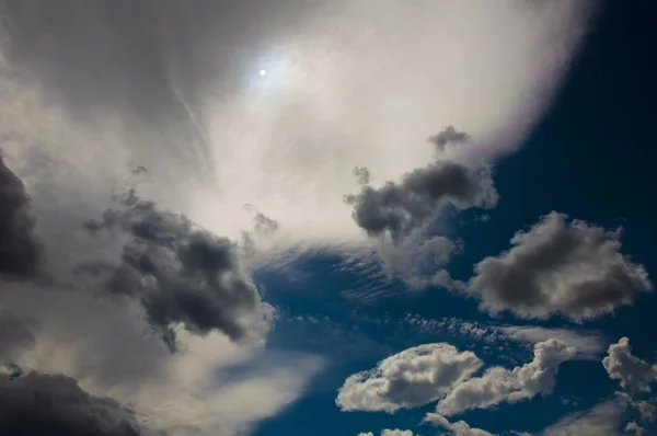 Jasne Ciemne Chmury Dziwaczne Formy Słońca Tle Ciemnego Niebieskiego Nieba — Zdjęcie stockowe