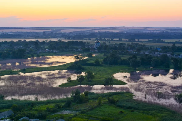 日の出前に夕暮れ時に湖 寺のある風景します Osinove 村ウクライナ ルガンスク地域 ストック画像