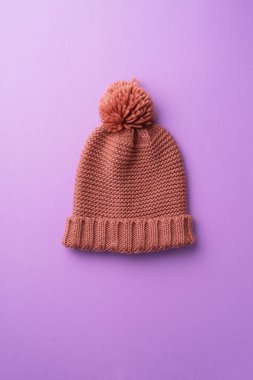 Mor arka plan üzerinde kış şapka örgü