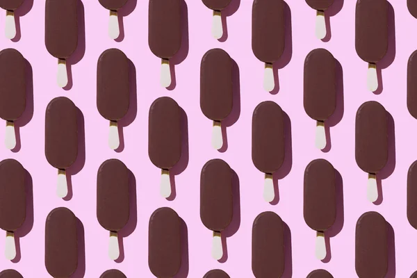Ice cream popsicles organized in a row over pink background