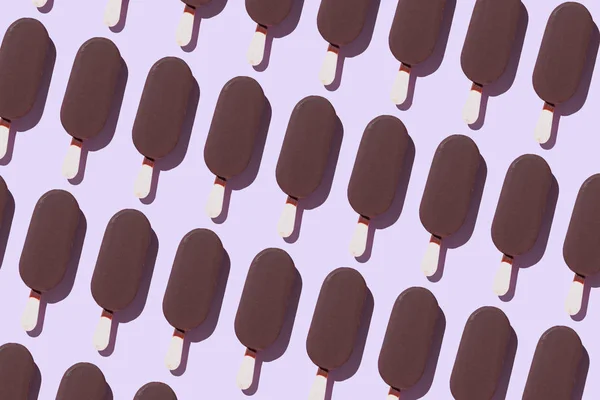 Ice cream popsicles organized in a row over purple background