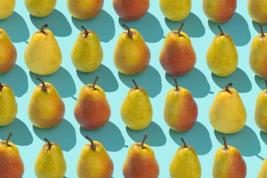 Multiple pears organized in a row over blue background clipart