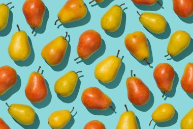 Birden çok armut mavi arka plan üzerinde bir satırda düzenlenen