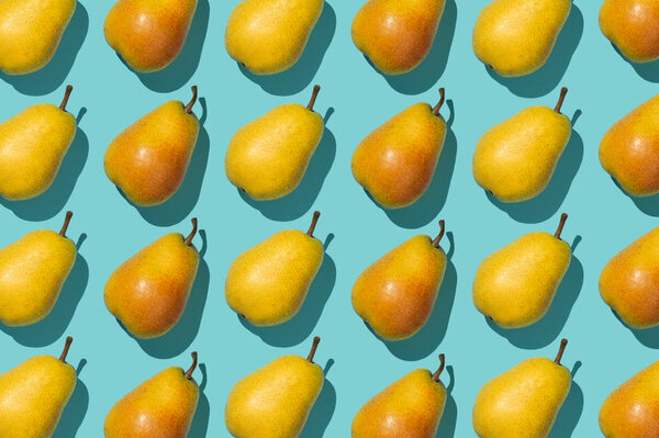 Несколько груш, организованных в ряд на синем фоне
