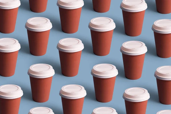 Disposable coffee cups organized in a row over blue background