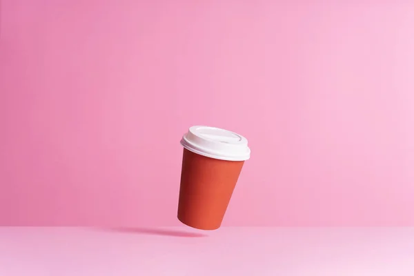 Einweg Kaffeetasse Der Luft Über Rosa Hintergrund — Stockfoto