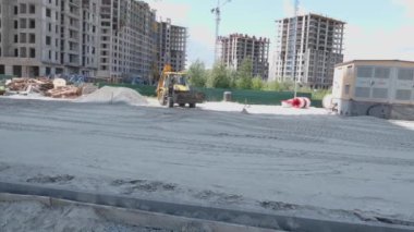 Kumlu bir inşaat sahasında kazı araçları