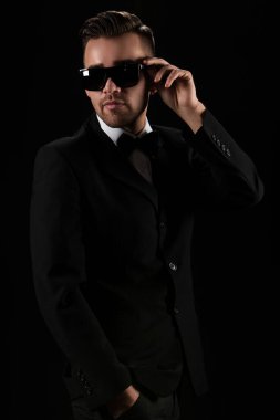 Siyah takım elbiseli çekici bir adam ve kelebek.