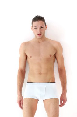 Beyaz bir arkaplanda spor yapan ve poz veren yakışıklı bir adamın portresi.