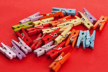 Kırmızı arka plandaki küçük renkli ofis mandallarının yakın plan görüntüsü