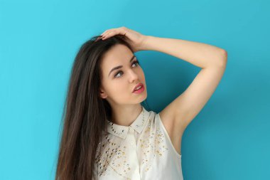 Mavi arka planda sevimli, çekici bir kadın.