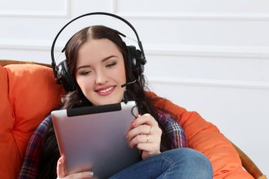 Yaşam tarzı. Tableti ve kulaklığı olan güzel bir kadın.