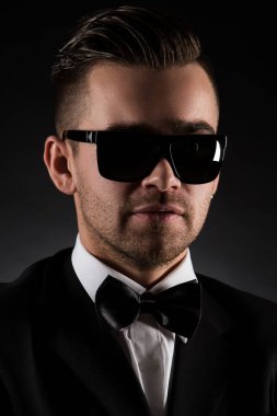 Siyah takım elbiseli çekici bir adam ve kelebek.