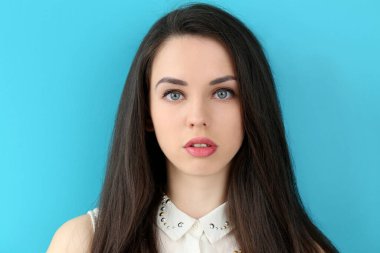 Mavi arka planda sevimli, çekici bir kadın.