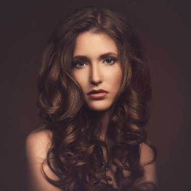 Kahverengi arka planda üzgün, sevimli bir kadın.