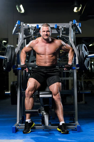 英俊而强壮的男人在健身房锻炼 — 图库照片