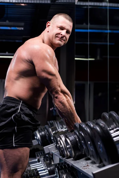 英俊而强壮的男人在健身房锻炼 — 图库照片