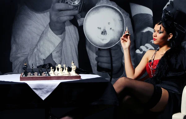 摆在象棋桌旁边的年轻和性感复古女人 — 图库照片
