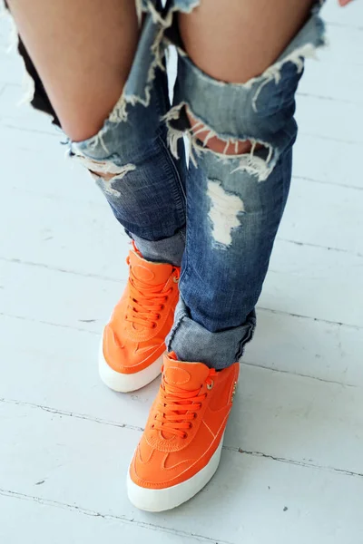 穿着破牛仔裤和橙色靴子的女人 — 图库照片
