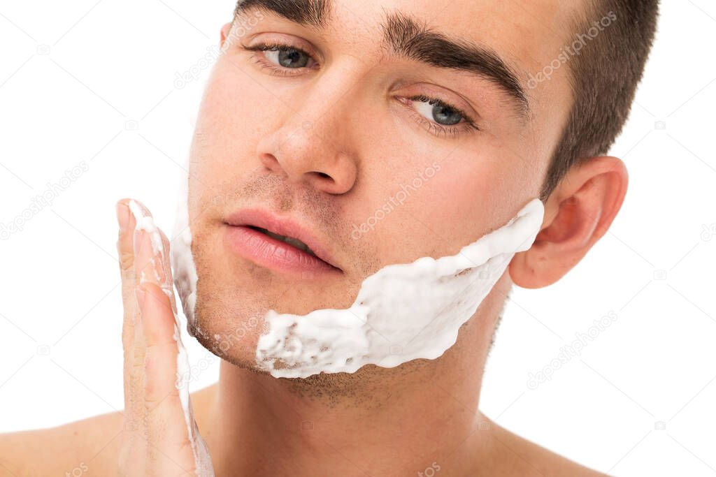 Man shaves his face
