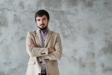 Palto giyen yakışıklı adamın stüdyo portresi.