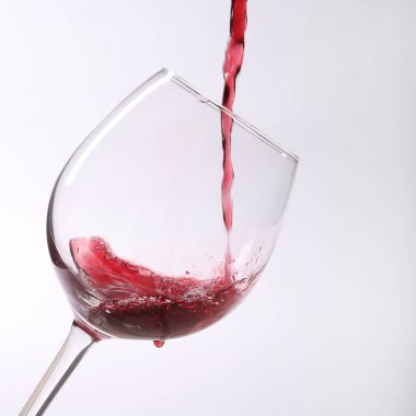 Şarap kadehine kırmızı şarap dökülüyor.