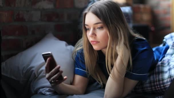 Młoda Kobieta Pomocą Smartfona Podczas Relaksu Przytulnym Łóżku Pokoju — Wideo stockowe