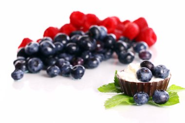 Beyaz arka planda taze ahududu, çiğ ve yabanmersini. 