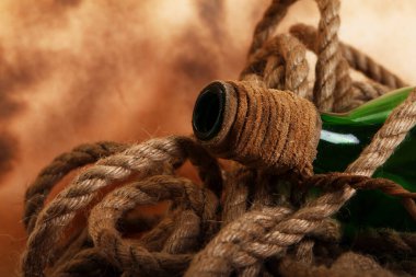 Eski arka planda eski bir şişe ve ip