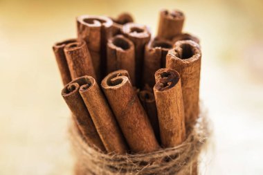 Ahşap bir yüzey üzerinde bir iple sarılı bir yığın tarçın.