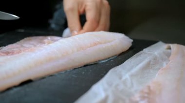 Şef bir restoranın mutfağında balık kesiyor. 