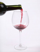 Červené víno se nalévá do sklenice na víno